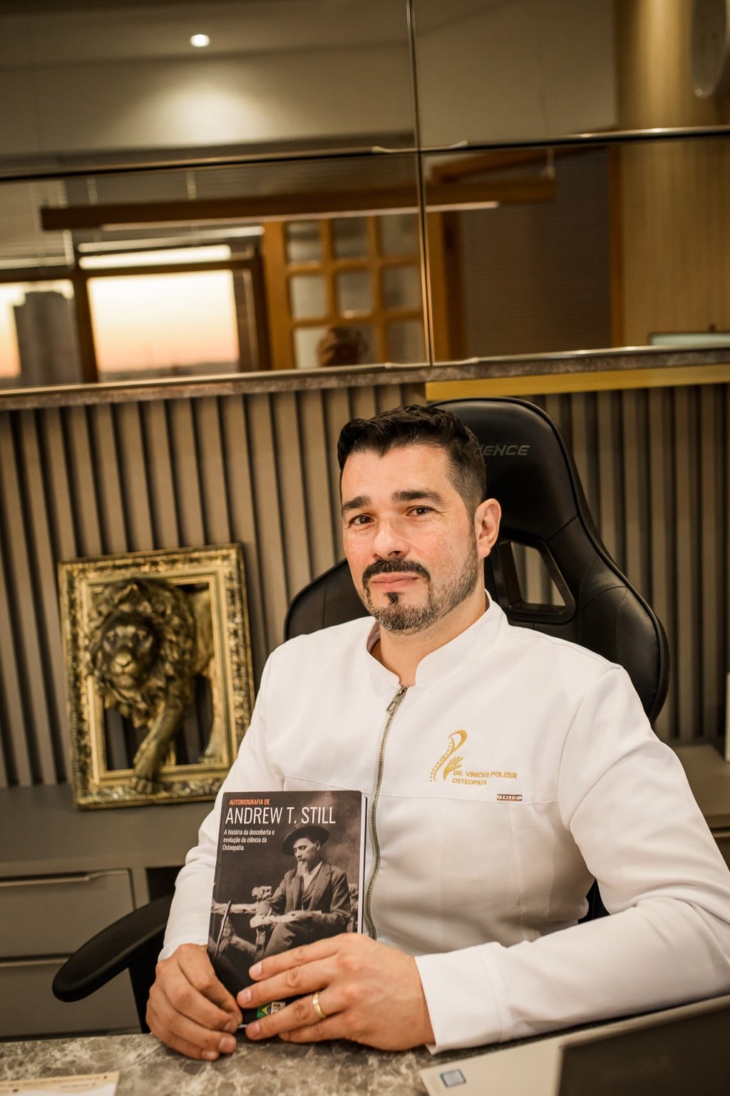 Dr. Vinicius Polizer segurando livro sobre Andrew T. Still